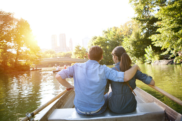 Couple have fun outdoor rowing boat on lake