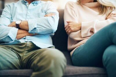 Cropped shot of an unrecognizable mature couple sitting on the sofa with their arms folded after an argument leading to divorce