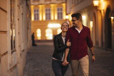 Happy young couple walkng in a beautiful city in the evening, passive-aggressive
