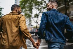 Gay couple walking in the rain holding hands