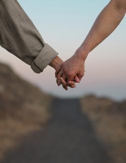 a couple holding hands by the beach
