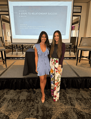 Two Maclynn matchmakers standing in front of a stage with a screen for their talk on 5 Steps to Relationship Success