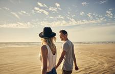 A couple walking on a beach and holding hands