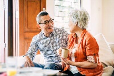Smiling happy Asian Senior lady with her partner drinking coffee