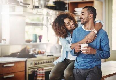 Shot of a happy young couple relaxing in the kitchen in the at home