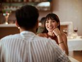 young woman smiling while on a date at a restaurant, flirting
