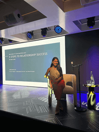 Sarah Powell, Maclynn matchmaker, sitting on stage to give a talk on 5 Steps to Relationship Success