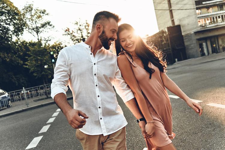 a couple holding hands and crossing the road, female and male couple