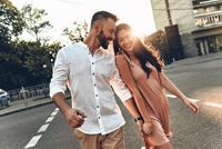 a couple holding hands and crossing the road, female and male couple