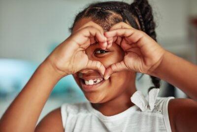 Cropped shot of a young girl forming a love heart shape with her hands