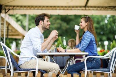 Loving couple at coffee house having coffee date and chatting