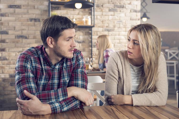 Young couple having a serious conversation in a bar.