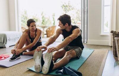 Couple exercising together. Man and woman in sports wear doing workout at home with their partner to achieve their core values