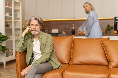 Low-spirited man propping his head with his fist, wondering if the grass is greener