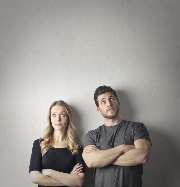 Couple is standing next to each other with their arms crosses
